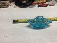 Blue opalescent glass basket dish with handle measuring approximately 5 to 6 inches in length, photo shows front side and handle details.