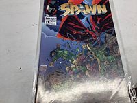 Photo of Spawn #11 comic book in protective sleeve showing full front cover with characters and title.