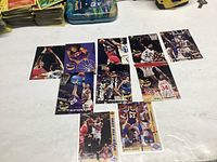 Overview of 9 Michael Jordan basketball cards arranged on table showing various action basketball shots including dunking and defense.