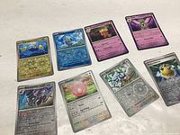 Lot of eight shiny Pokémon cards spread out showing front of each card with visible shiny foil effects, featuring Clamperl, Cryogonal, Espurr, Meowstic, Revavroom, Chansey, Xerneas VSTAR, and Rocky Helmet Trainer.