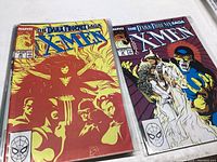 Two of the seven Marvel Dark Phoenix Saga X-Men comic books showing front covers, one with fiery red Phoenix figure and the other with a purple background character.