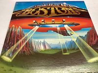 Front cover of Boston's debut vinyl album showing the spaceship in flight over a rocky landscape with futuristic buildings.