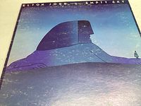 Front album cover with stylized sphinx illustration and text 'Elton John Empty Sky'