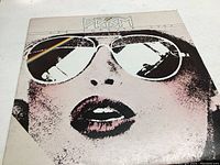 Front of the vinyl record album cover showing stylized artwork of face with reflective prism sunglasses.