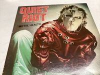 Vinyl record cover with masked figure in red jacket, titled Quiet Riot Metal Health