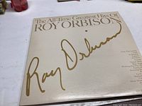 Front cover of The All-Time Greatest Hits of Roy Orbison vinyl record showing signature and title text on cream background.