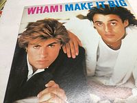 Front cover of 'Make It Big' album showing Wham! members and title