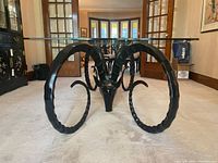 Full front view of the dining table showing glass top and both antelope head bases