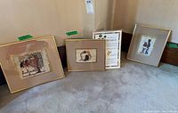 Three Egyptian papyrus art pieces placed on carpet, all framed with gold metal frames and glass fronts. Sizes and matting vary.