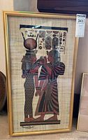 Full view of framed Egyptian papyrus with two figures.