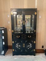 Front view of the lacquered hutch cabinet showing glass-front upper section with inlaid panels and mirrored back