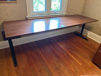 Full view of the wood work table showing the rectangular tabletop and metal legs.