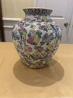 Front view of ceramic vase showing colorful floral and butterfly design on white base