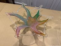 Front angled view of colorful starburst Murano glass centerpiece on table showing appendages and color gradients.