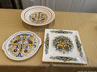 Photo of 3 Deruta ceramic items: 2 platters and 1 pasta bowl on table.