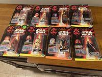 Group of 11 Star Wars figures in original packaging, featuring Episode I characters and others.