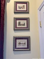 Set of three vertically aligned framed pictures of Florence on a pale yellow wall near a door frame.