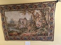 Front view of large Florence countryside tapestry hanging on a black rod above a light switch.