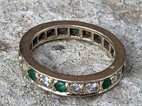 Top view showing alternating emerald and diamond stones around the band