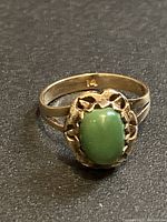 Front view of ring showing green jade cabochon and decorative bezel