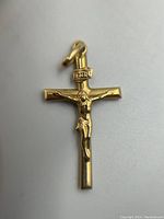 Front view of 14K gold crucifix pendant showing full figure of Jesus and loop attachment.