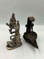 Front view of Tibetan statue and iron whale oil lamp.