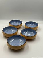 Photo showing set of five blue glazed Japanese pottery bowls from above and angled side view.