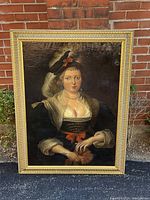 Full view of framed oil painting against brick background showing subject and frame