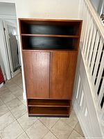 Front view of closed bookcase showing six tiers and black back panel