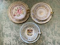 Top-down view of three Paragon cups and saucers showing interior designs and gilding