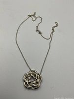 Full view of pendant necklace laid flat on white background