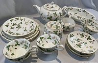 Array of Wild Strawberry tea and dinner pieces including teapot, cups, saucers, plates, creamer, sugar bowl, and tray