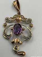 Close-up of pendant front showing central oval amethyst and seed pearl accents