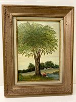 Full view of framed painting showing a boy fishing under a large tree by a river with houses in the background.