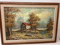 Framed oil painting of a cottage landscape with a pond and trees under a cloudy sky.