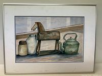 Full view of the framed watercolour painting featuring a still life with a wooden horse sculpture, ceramic jar, jug, and metal kettle.