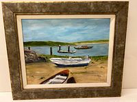 Framed lakeside oil painting featuring boats on shore and water, surrounding landscape with hills and dock.