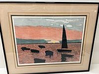 Front view of the framed etching showing the coastal scene with silhouetted boats and a large sail against a pinkish sky.