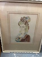 Full view of framed artwork depicting the lady with an elaborate bow hat and flowers, showing the entire frame and matting.