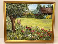 Front view of the framed oil painting showing a large tree with dense foliage and foreground filled with red, purple, and white flowers alongside a distant barn.