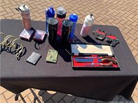 Photo of the carving set, water bottles, wallets, and playing cards arranged on a table.