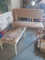 Photo of two upholstered benches with metal frames, showing cushioned patterned fabric seats and backs.