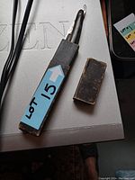 Antique straight razor partially folded inside its worn black leather case with a removable cap.