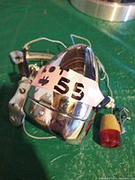 Front headlight with chrome finish, reflective interior, and mounting bracket shown with lot number tag.