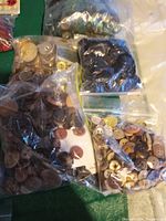 Multiple plastic bags of assorted buttons in various colors and materials including wood and cork, mostly new, good condition.