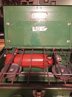 Closed view of green Coleman camping stove showing logo plate and latch