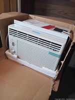 Front and side view of the Goldstar 5050 air conditioner in its original box held by foam padding.