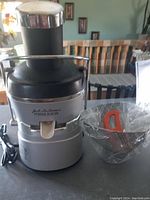 Front view of Jack LaLannes Power Juicer with glass container beside it