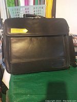 Closed view of black leather executive laptop case showing front flap and stitching details