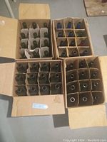 Four open cardboard boxes, each containing 12 empty green glass wine bottles separated by cardboard dividers, total 48 bottles.